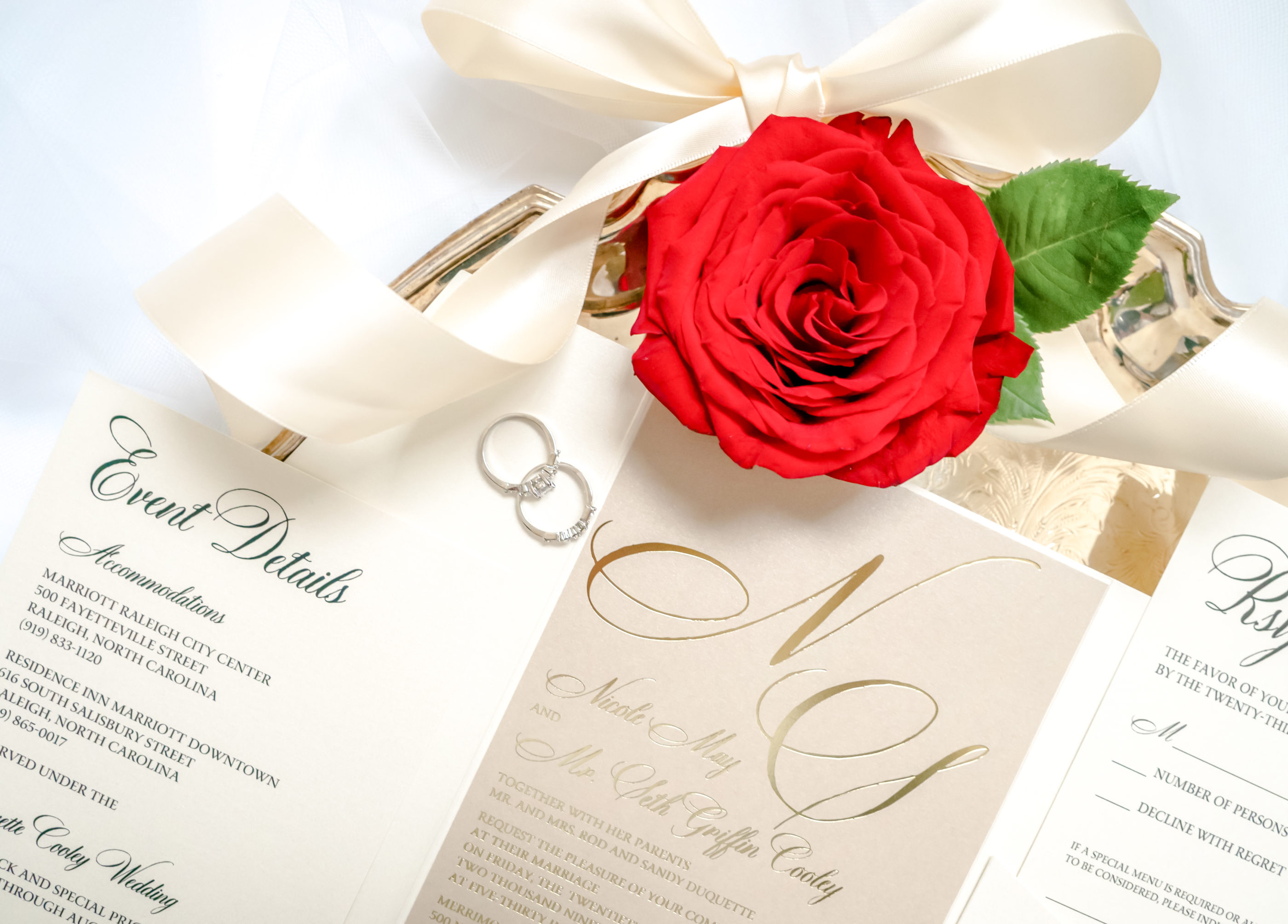 close photograph of cream, taupe, and gold foil embossed invitation suite