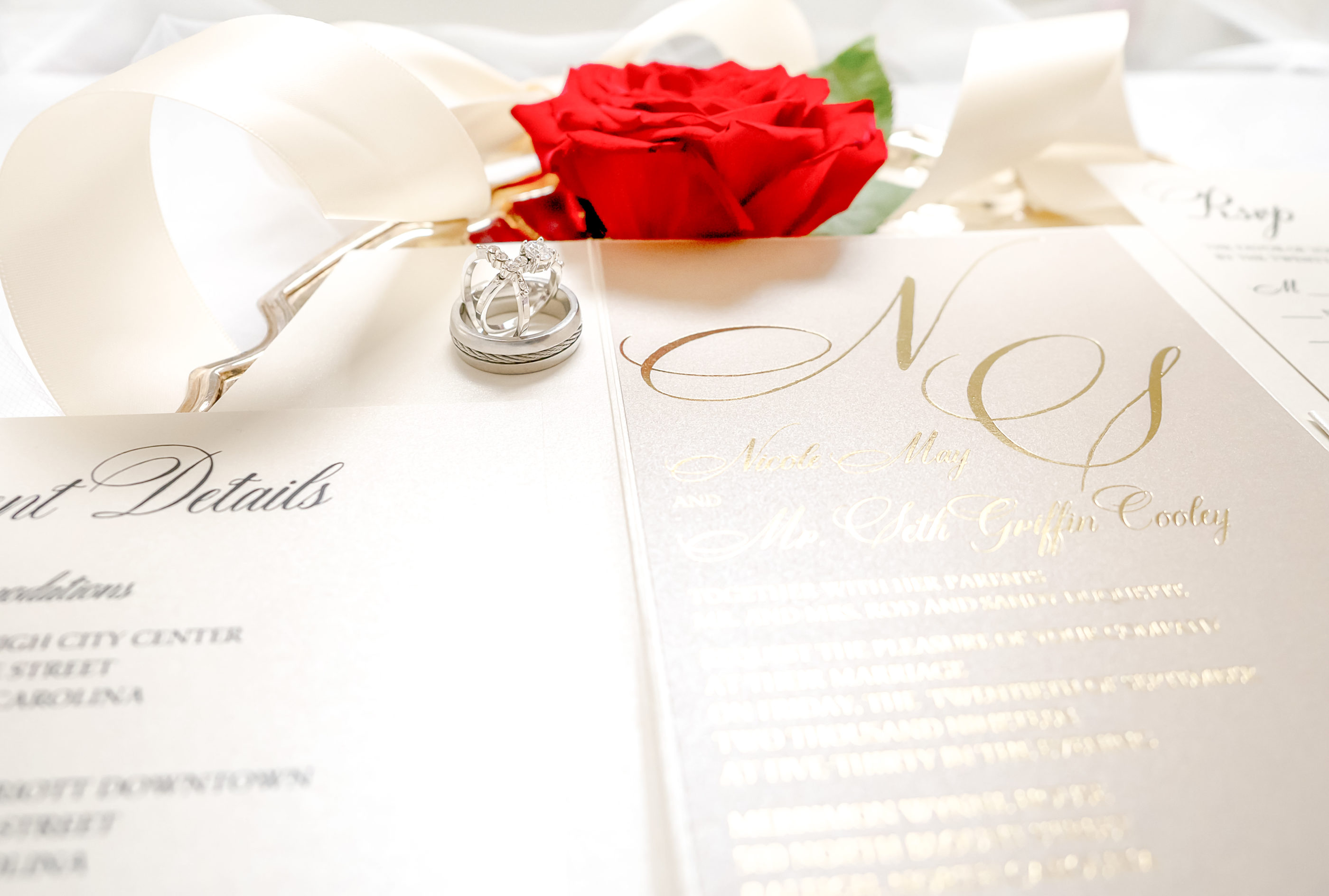 close photograph of cream, taupe, and gold foil embossed invitation suite showing the foil shine