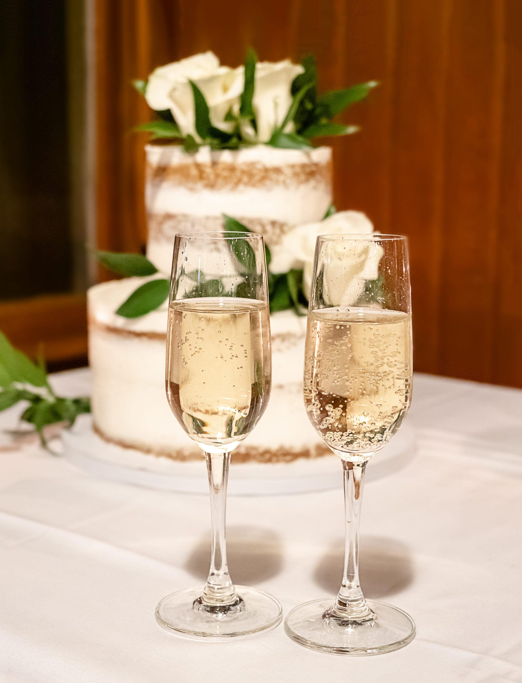 wine glasses for toasting in front of the wedding cake