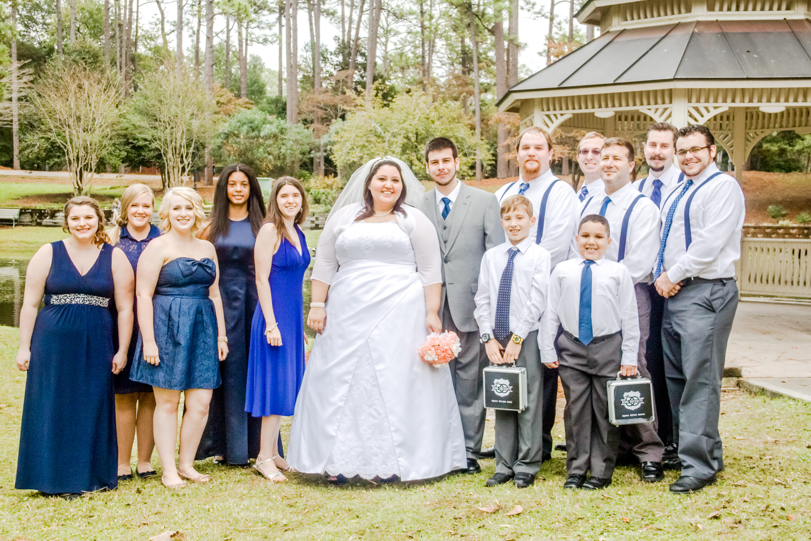 bridesmaids and groomsmen with ring bearers and wedding couple in front of gazebo