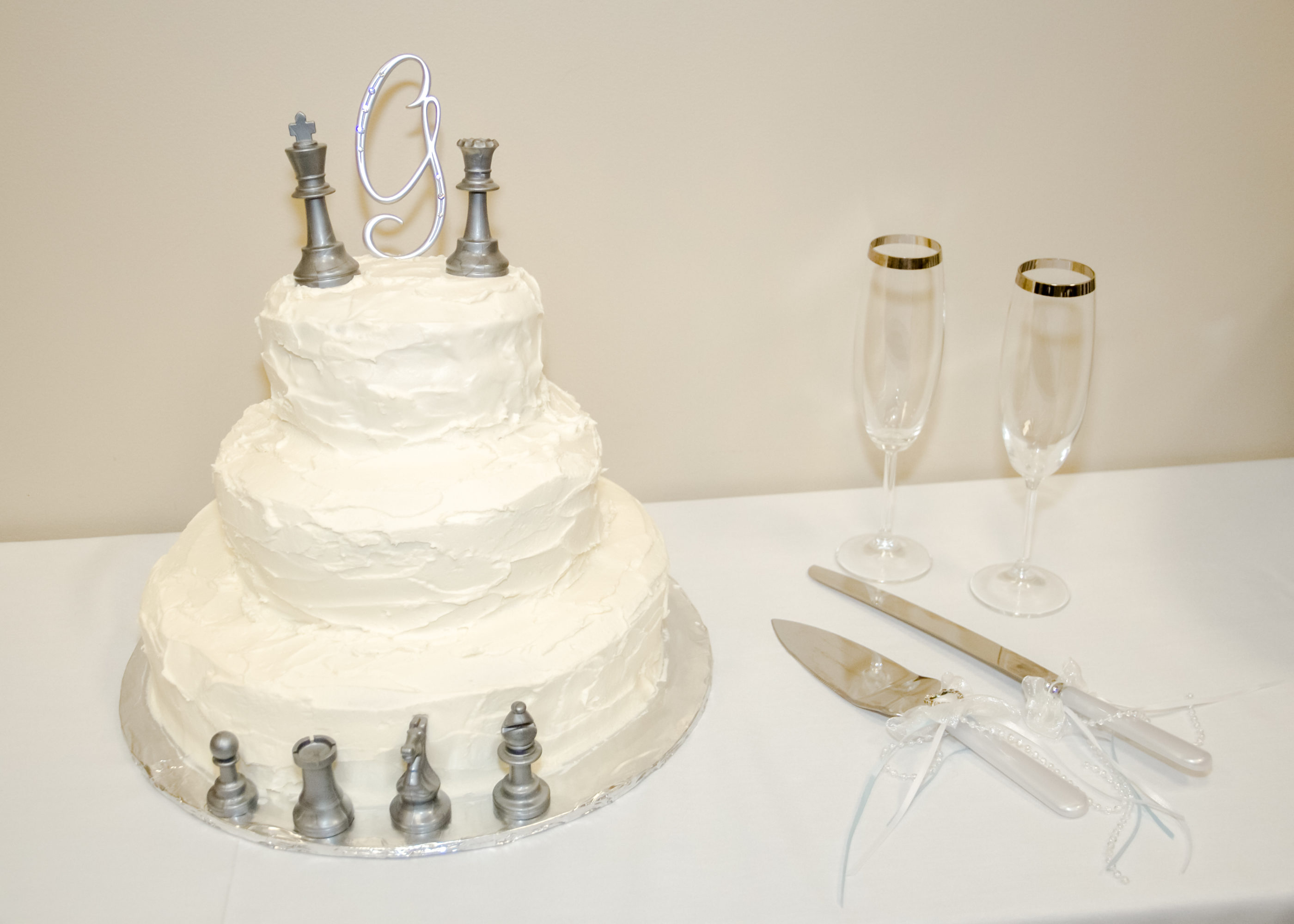 three tier white wedding cake with chess pieces