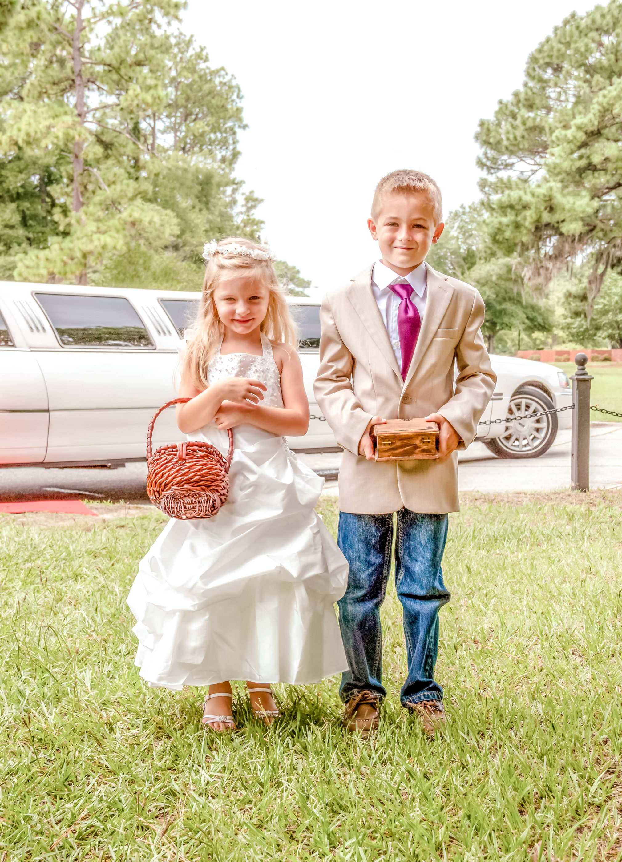 flower girl and ring bearer outside in front of the limo