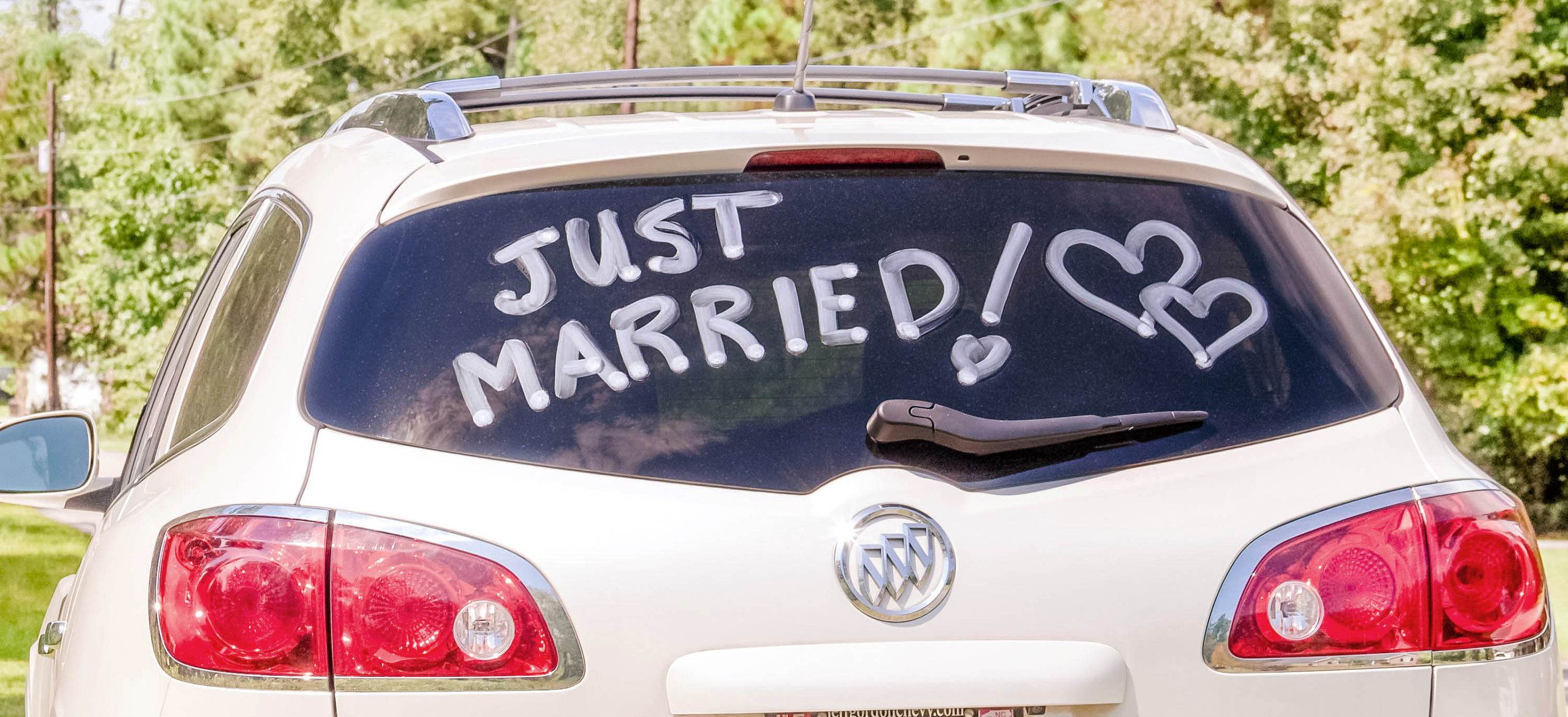 bride and groom's car with just married written on the back window