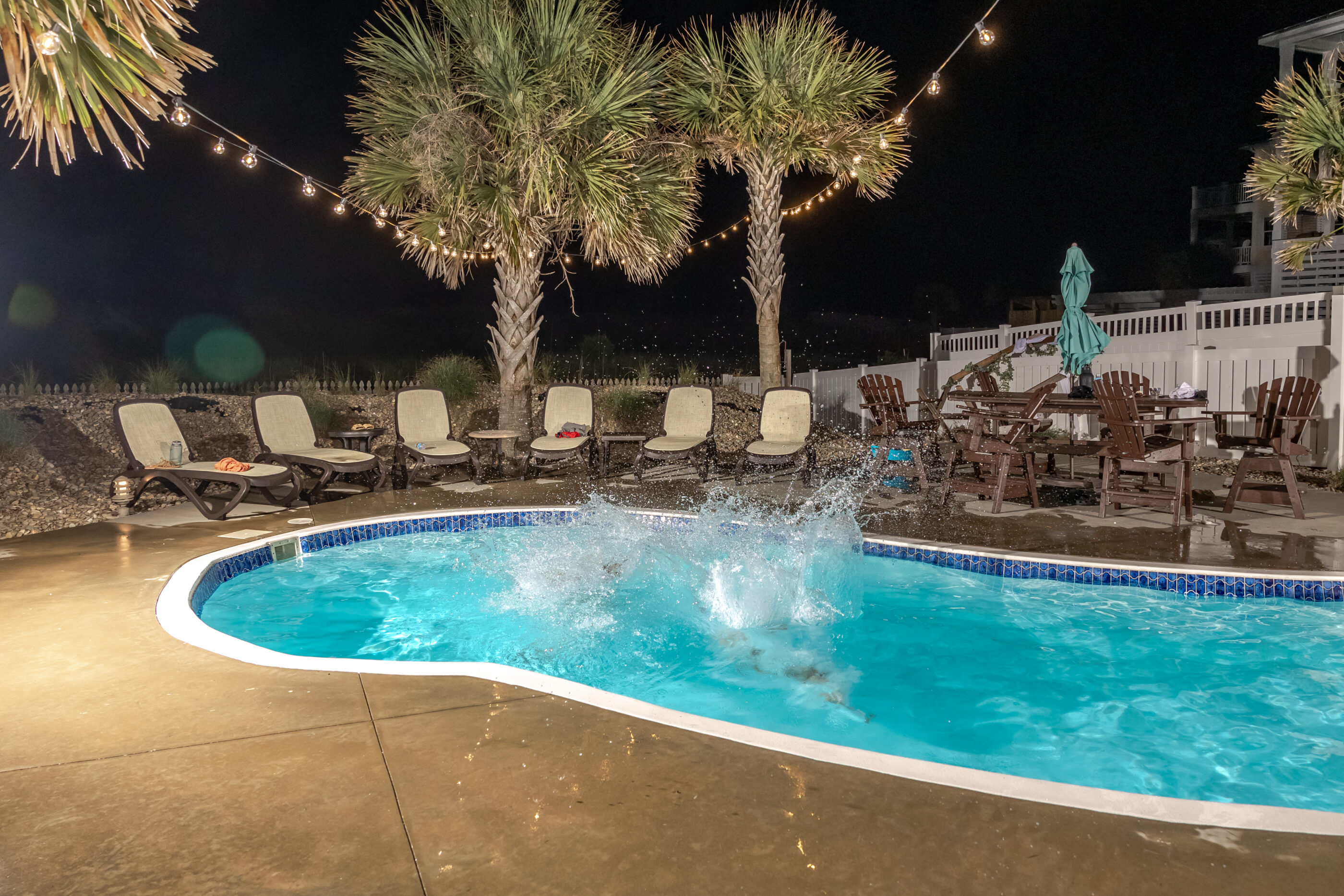 Water splashes in the pool after a wedding couple's jump, leaving only the aftermath visible.